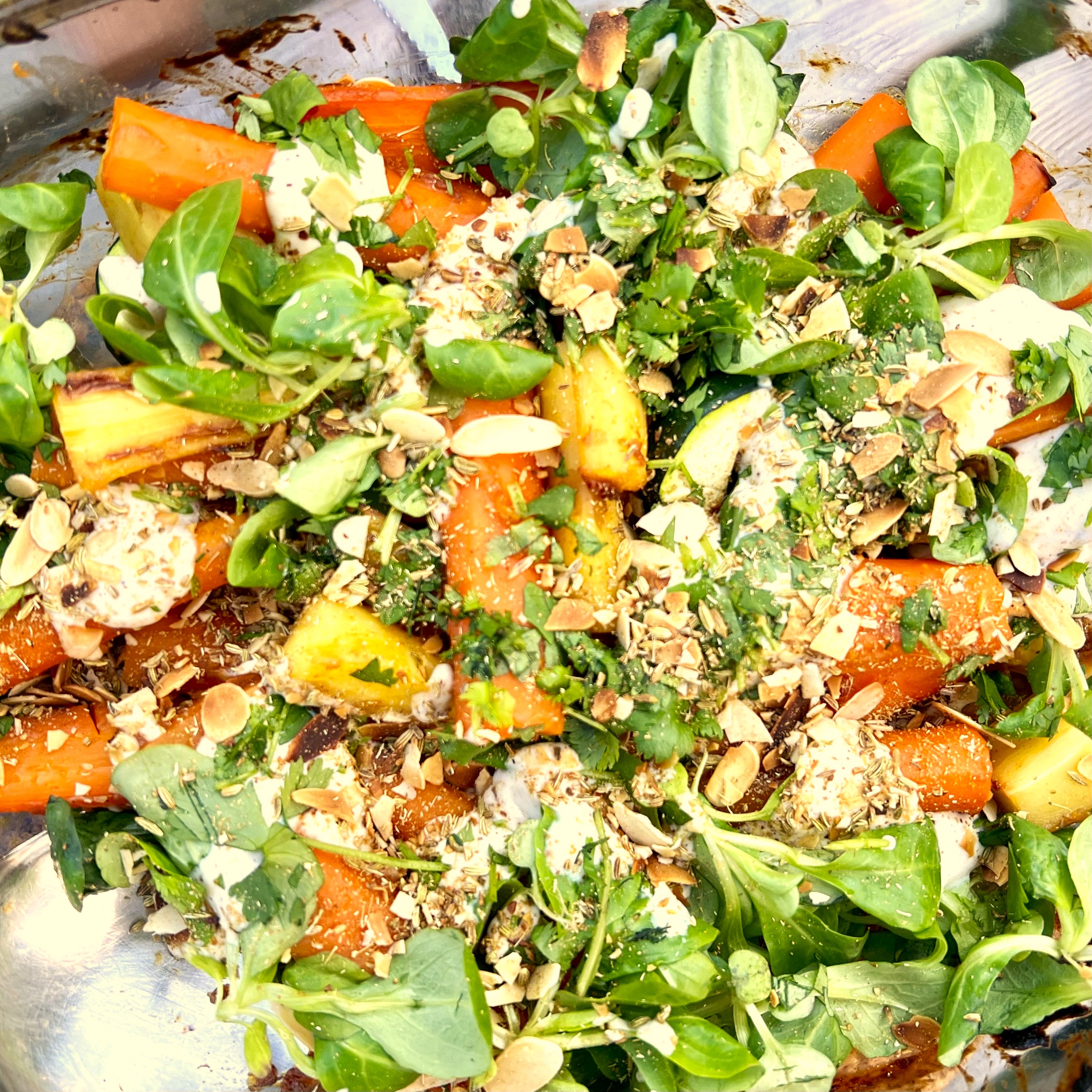 Roasted carrots and pumpkin scattered with watercress, almonds, and a yogurt-herb dressing