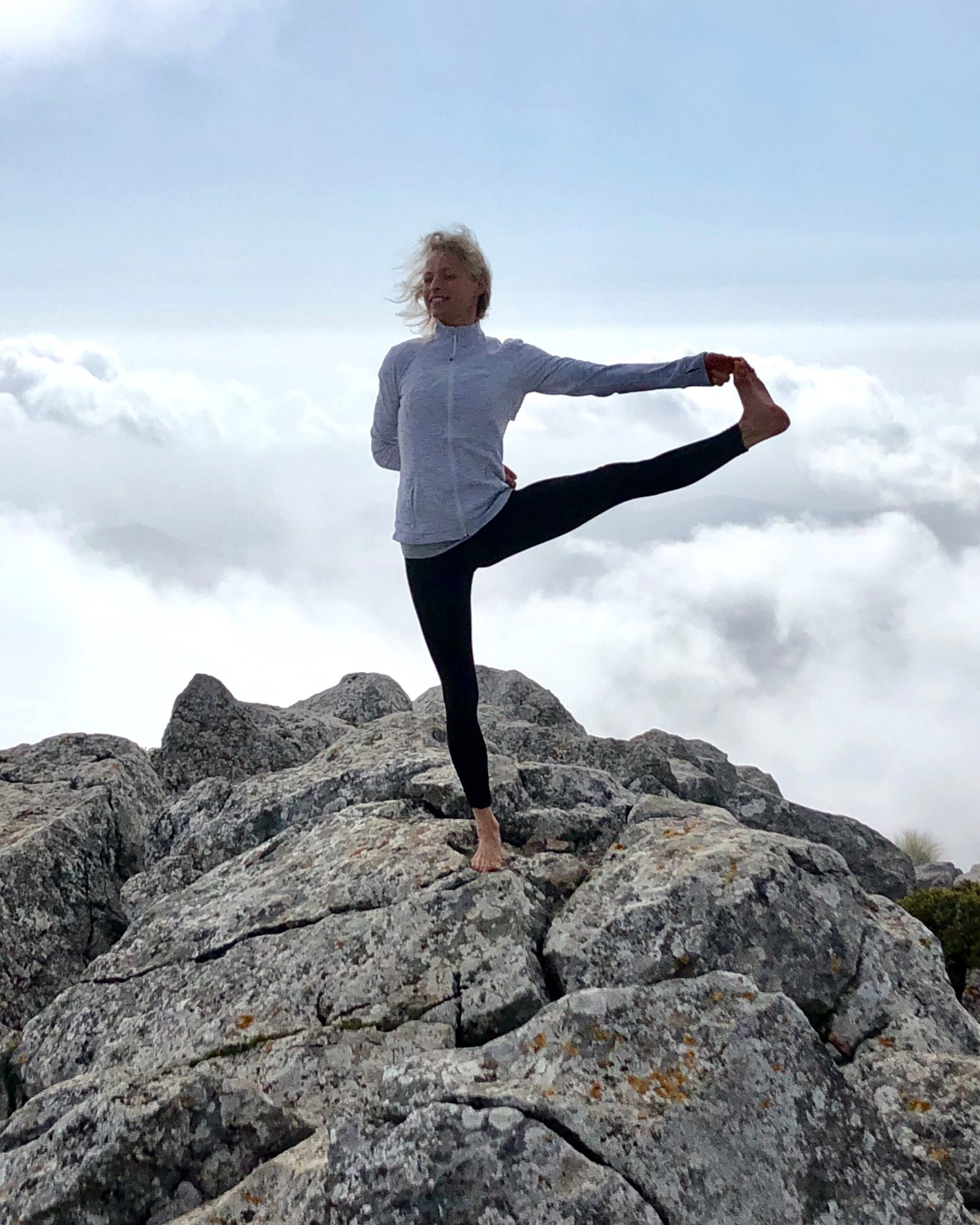 Hanna in a standing balance pose above the clouds in Mallorca